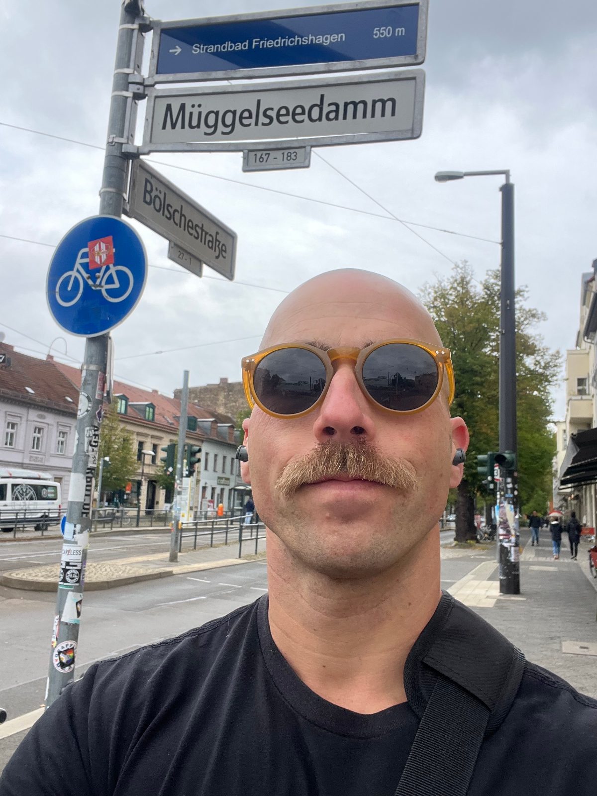 Coach Adam on a Berlin street corner, beneath signs for Müggelseedamm and Bölschestraße.