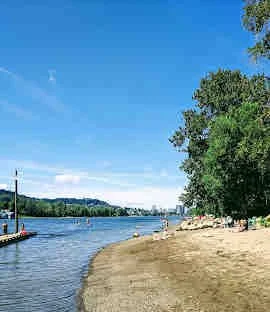 Sellwood Riverfront Park’s sandy beach along the Willamette River on a sunny day.